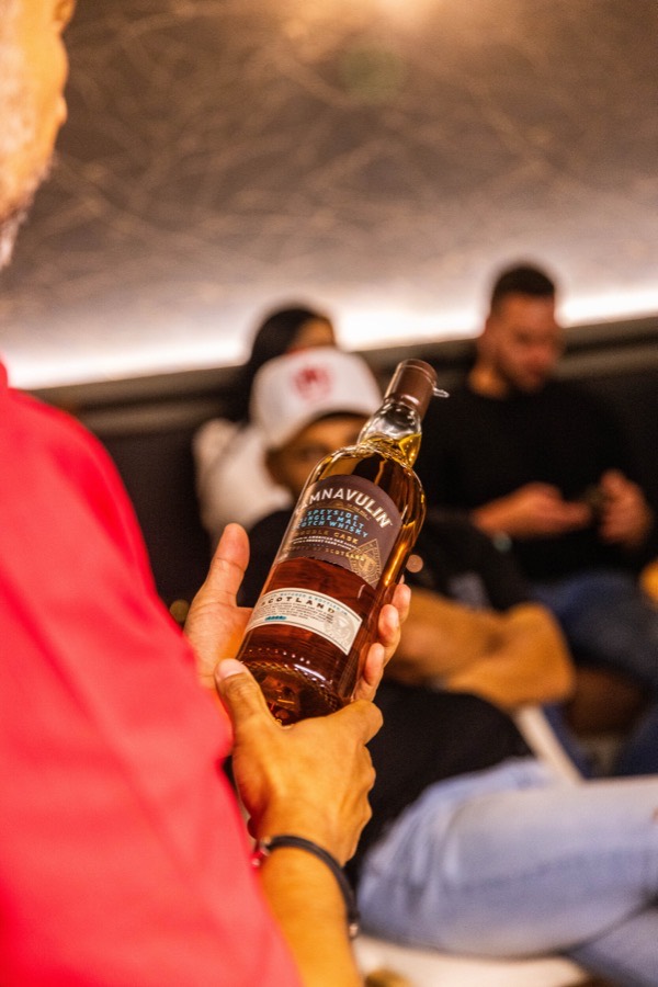 Guía presentando botella de single malt escocés a los asistentes de la cata