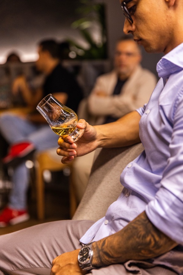 Asistente examinando el whisky en su copa durante la cata