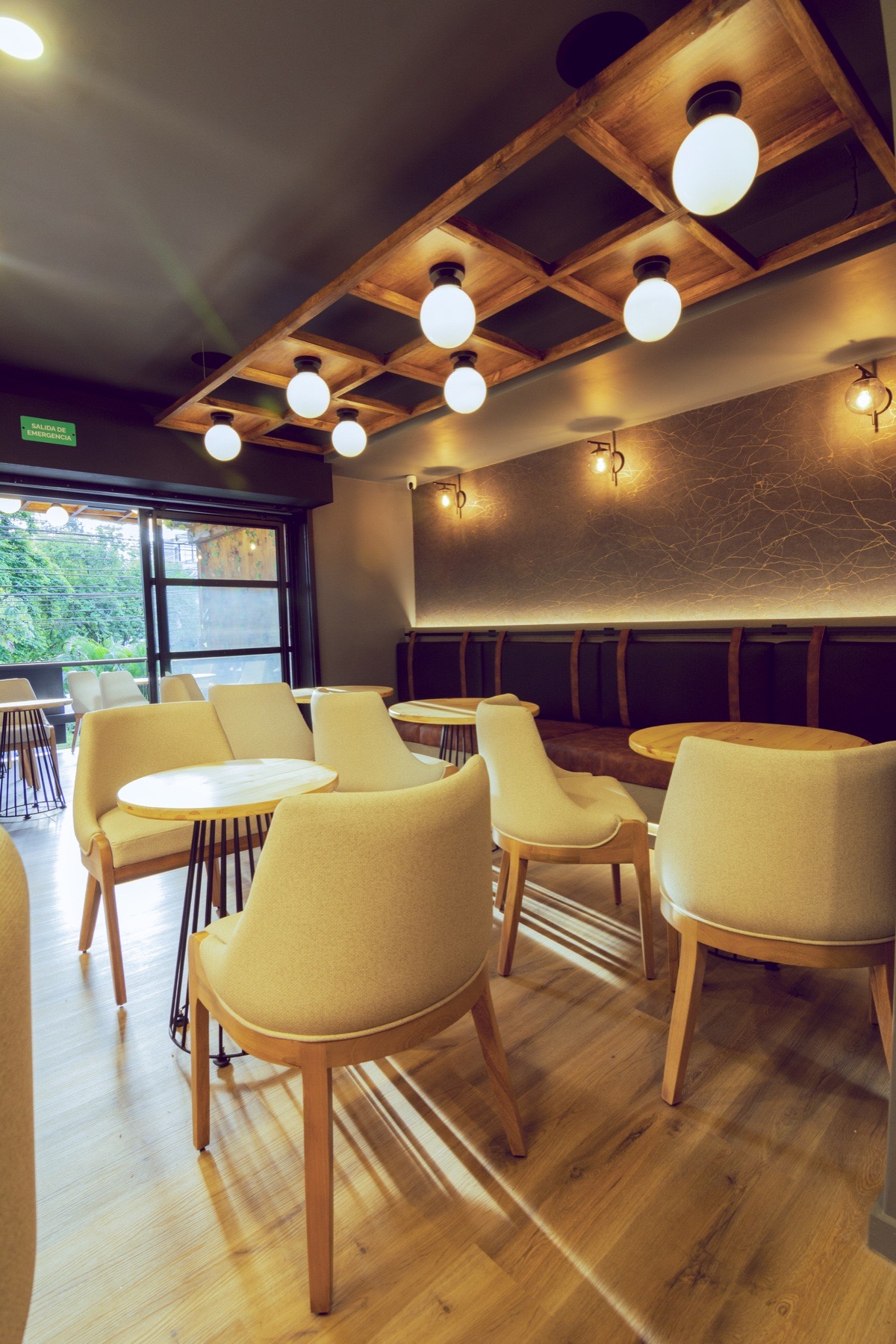 Salón de La Boutique del Whisky en El Poblado con mesas y luz natural